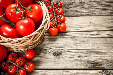 Olgun domates bir sepet içinde. Ahşap bir arka plan üzerinde.