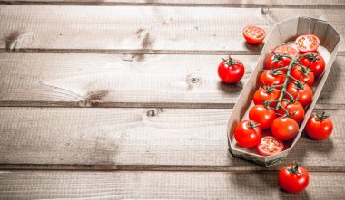 Taze domates içinde belgili tanımlık tepsi. Ahşap bir arka plan üzerinde.