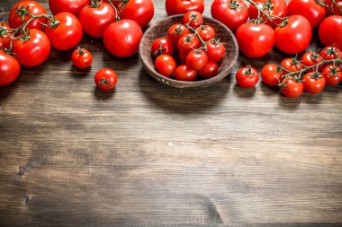 Olgun domates bir kase. Ahşap bir masaya.