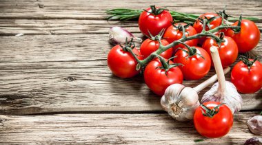 Taze domates sarımsak ve otlar ile. Ahşap bir masaya.