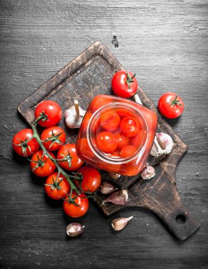 Turşusu domates sarımsak ve otlar ile. Siyah arka plan üzerine.