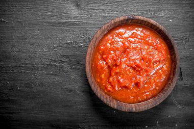 Kase domates sosu. Siyah arka plan üzerine.