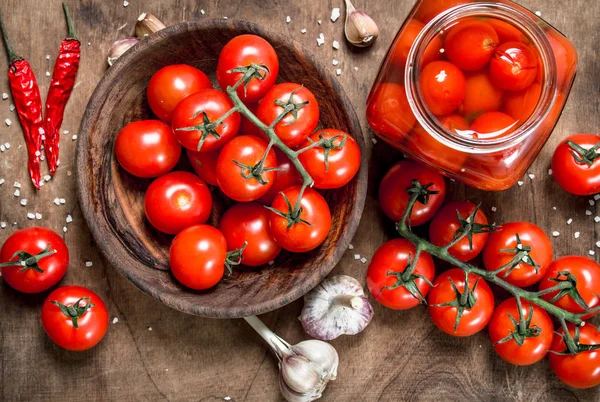 Turşusu domates sarımsak ve baharat ile. Ahşap bir masaya.