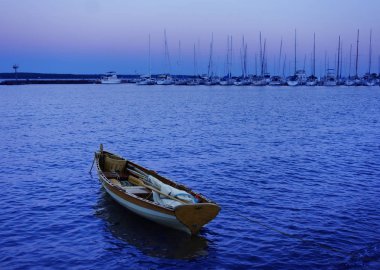 Small sailboat at the marina at dusk in Bayfield Wisconsin with the Apostle Islands in the distance                                clipart