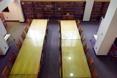 Uzun tablolarla bir kütüphane kitap ve sandalyeler                               