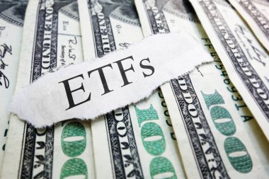 ETFs ( Exchange Traded Funds ) newspaper scrap on assorted money                                clipart