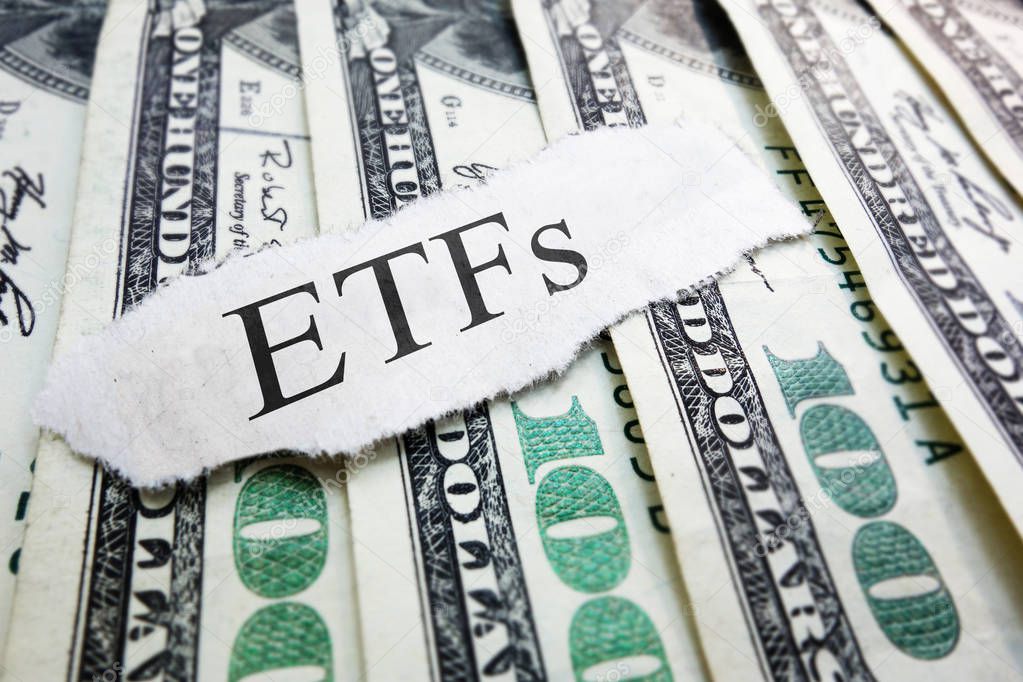 ETFs ( Exchange Traded Funds ) newspaper scrap on assorted money                               