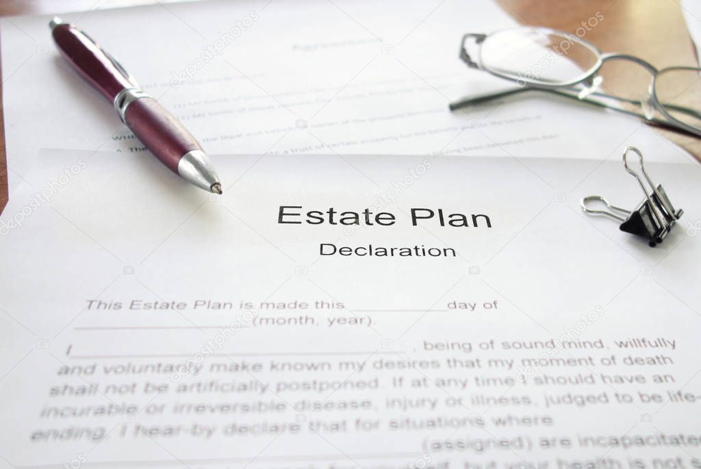 Estate Plan document on a desk with a pen and glasses                               