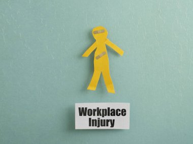 Paper cutout person with bandages and Workplace Injury message                                clipart