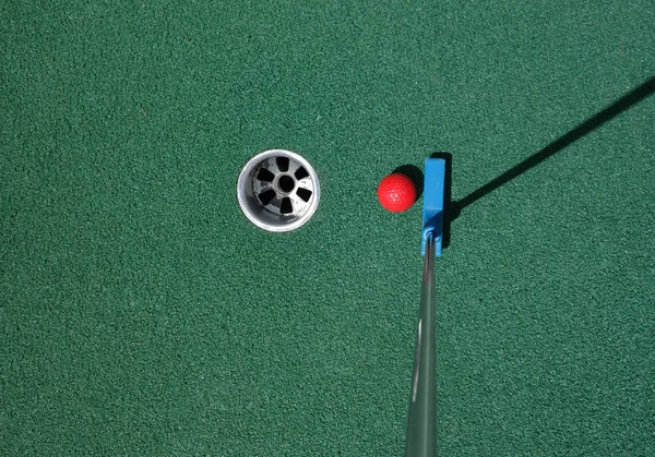 Mini golf sahasında topu koyarak — Stok fotoğraf