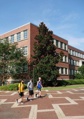RALEIGH, NC / USA - 8-10-2020: Coronavirus salgını sırasında sonbahar dönemi derslerine döndükten sonra Raleigh, NC Devlet Üniversitesi 'nde maskeli öğrenciler kampüste yürüyor