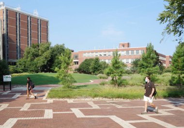 RALEIGH, NC / USA - 8-10-2020: Coronavirus salgını sırasında sonbahar dönemi derslerine döndükten sonra Raleigh, NC Devlet Üniversitesi 'nde maskeli öğrenciler kampüste yürüyor