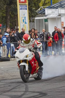 Bucharest, Romanya - 25 Nisan 2010: Motosiklet binici Angyal Zoltan bir tükenmişlik onun kırmızı ve beyaz sportbike düzenlenen Romexpo Fuar Merkezi Smaeb gösterisi sırasında gerçekleştirir.