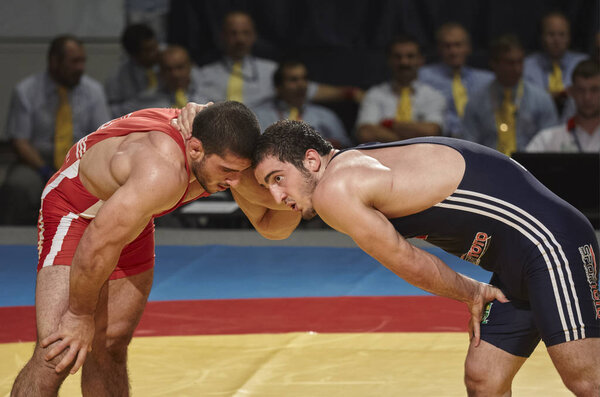 Бухарест, Румыния - 27 июля 2011 года: Два истощенных борца делают небольшой перерыв в интенсивной борьбе во время Чемпионата мира по борьбе среди юниоров, проходившего в Поливалентном зале
.