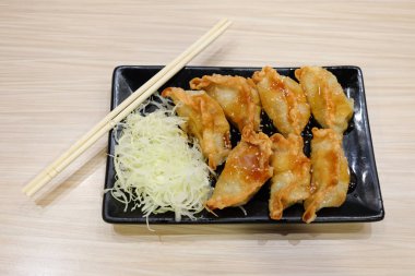 Lahana ile ev yapımı sosu chopsticks Çin yemeği arka plan veya doku ile siyah plaka üzerinde hizmet.