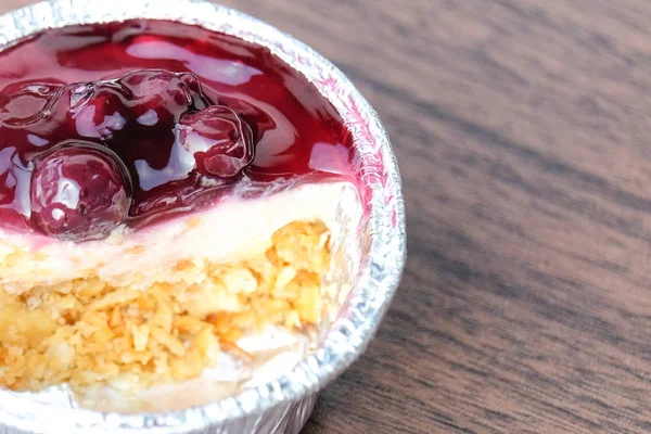 Tarta de queso azul en taza de papel de aluminio (hecha en casa) con mesa de madera para fondo o textura de postre - concepto de comida . — Foto de Stock