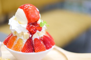Çilekli kakigori (vanilyalı vanilyalı buzlu tatlı aromalı Japon tatlısı) veya bingsu (Kore tatlısı) tatlı yemek arkaplanı veya doku için çilek soslu beyaz kasede servis edilir..