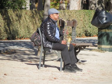 Madrid, İspanya - Ekim 2017 yaklaşık: tanımlanamayan Sokak müzisyeni Madrid Retiro Park alto saksafon oynamaya