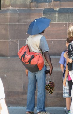 Strasbourg, Fransa - Temmuz 2013 yaklaşık: unidentifed siyah Afrika adam kafasına kolye satan bir şemsiye ile