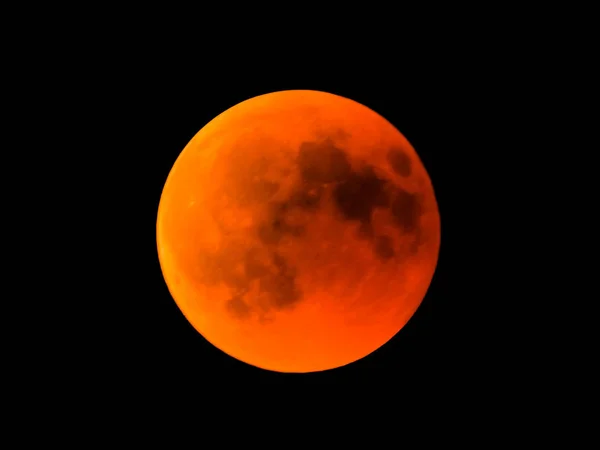 月蚀时用望远镜观测到的红月亮月亮经过地球后进入它的阴影 — 图库照片