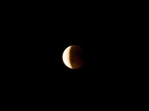 月蚀时用望远镜观测到的红月亮月亮经过地球后进入它的阴影 — 图库照片