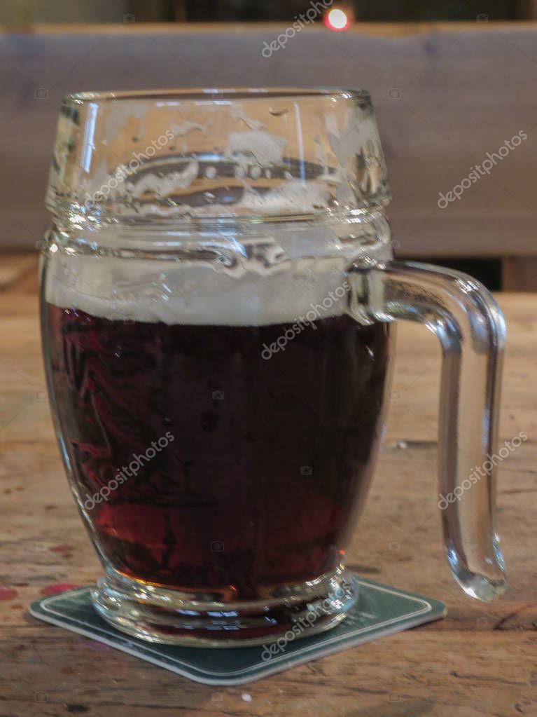 PRAGUE, CZECH REPUBLIC - CIRCA MARCH 2015: a glass of Czech stout beer Kozel, with logo, on the table