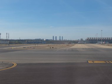 Madrid, İspanya - Ekim 2017 yaklaşık: Madrid-Barajas, Adolfo Suarez Havaalanı Uçak ve Cuatro Torres iş alanı gökdelenler (Torre eren, Torre de Cristal, Torre Pwc ve Torre Cepsa ile)