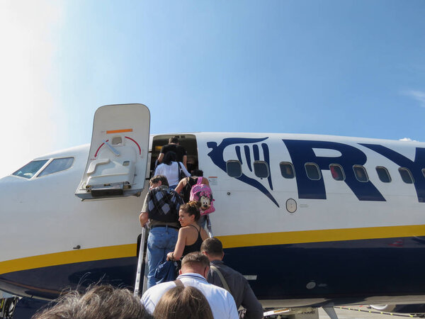 ORIO AL SERIO, ITALY- CIRCA SEPTEMBER 2014: Ryanair Jet aircraft on the runway with passengers boarding. Ryanair is the biggest low-cost airline company in the world