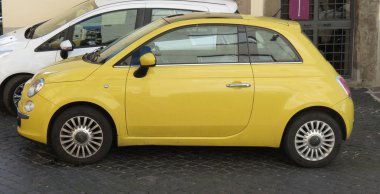 Rome, İtalya - Ekim 2015 yaklaşık: şehir merkezinin bir sokakta park edilmiş sarı Fiat 500 araba (yeni sürüm)