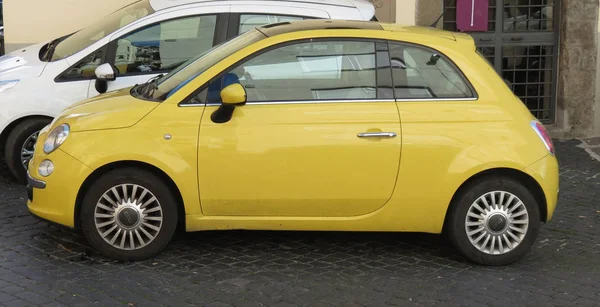 Rome, İtalya - Ekim 2015 yaklaşık: şehir merkezinin bir sokakta park edilmiş sarı Fiat 500 araba (yeni sürüm)