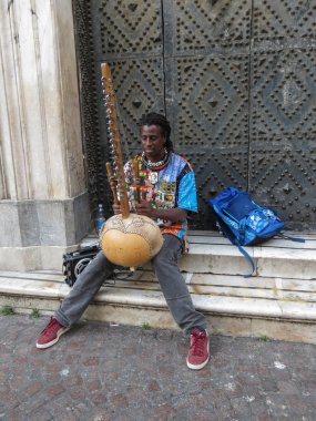 Napoli'de sahne alan tanımlanamayan Afrikalı arp kora çalar