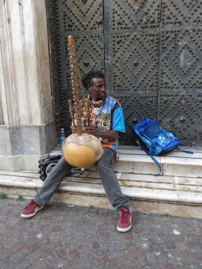 Napoli'de sahne alan tanımlanamayan Afrikalı arp kora çalar