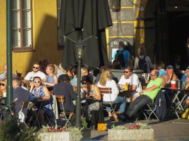 İnsanlar Oslo 'da açık hava barında oturuyorlar.