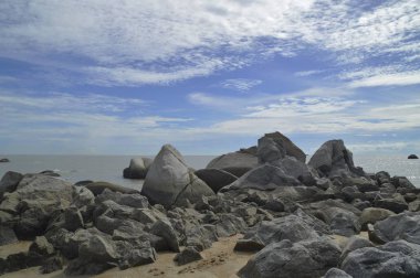 Bulutlu gökyüzü ile kayalık plaj