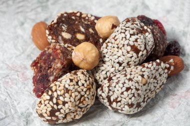 fındık ve buruşuk bir beyaz kağıt üzerinde kızılcık kızılcık ve şekersiz susam ile el yapımı şekerlemeler dağdan yatıyor. Yakın çekim manzaralı