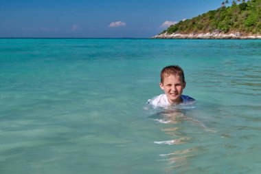 Neşeli çocuk küveti tropikal deniz güneşli bir gün. Şirin çocuk turkuaz içinde yüzme temiz su. Denizde tatil kavramı.