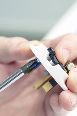 Erkekler el elektrik prizinden toplandı. Parmak tornavida tutun ve vidasını sıkın. Onarım kavramı.