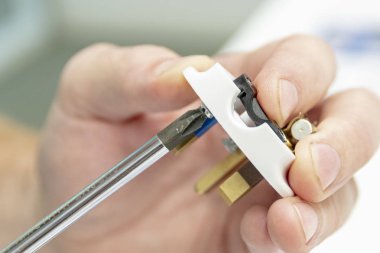 Erkekler ellerini ve elektrik prizinden toplamak. Parmak vida bir tornavida ile bükmek. Onarım kavramı.