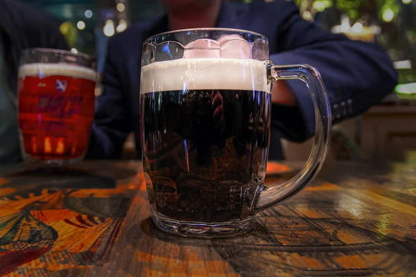 Large mug of dark beer with white foam on  vintage wooden table. — Stock Photo, Image