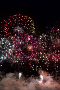 Siyah arka plan üzerinde kırmızı, altın, yeşil ve mavi havai fişek.