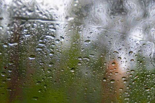 Gotas de chuva em uma janela. Floresta Outono Blur no fundo. Paisagem chuvosa outonal . — Fotografia de Stock