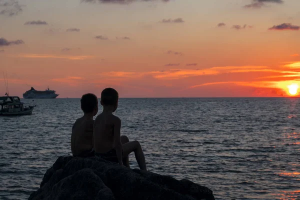 Silueta de dos chicos en el paisaje marino de la noche . — Foto de Stock