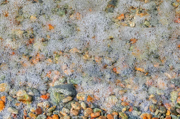 Primer plano de espuma y guijarros en la playa de verano. Surf . —  Fotos de Stock