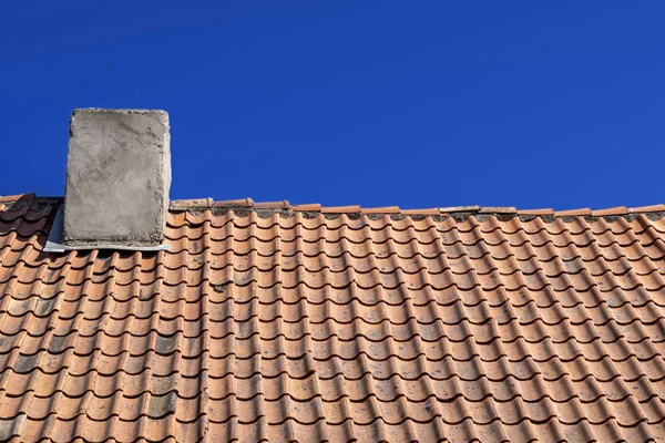 Kilden yapılmış geleneksel eski Kiremit Çatı. Doğal çatı malzemesi. Mavi gökyüzünün arka planında bacalı kil karolar. — Stok fotoğraf