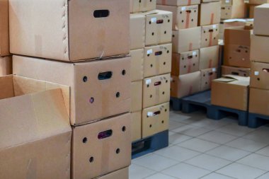 Depolama tesisinde yığınlar halinde karton kutular
