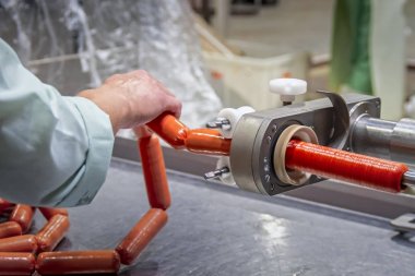 Sosis üretim hattı. Sosis fabrikası işçileri haşlanmış sosis üretiyor. Et fabrikasında sosis modern üretim hattı.