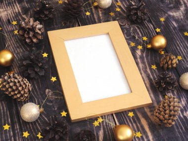 ahşap bir masada koni ve Noel dekorasyonu ile şablon altın fotoğraf çerçevesi mock. 