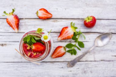 Kavanoz içinde taze meyve ve tahıllar ile sağlıklı ve lezzetli çilek güler yüzlü.