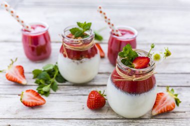 Kavanoz içinde taze meyve ve tahıllar ile sağlıklı ve lezzetli çilek smoothies. 