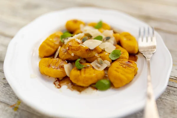 Pumpkin gnocchi with brown buttery sauce and parmesan cheese.